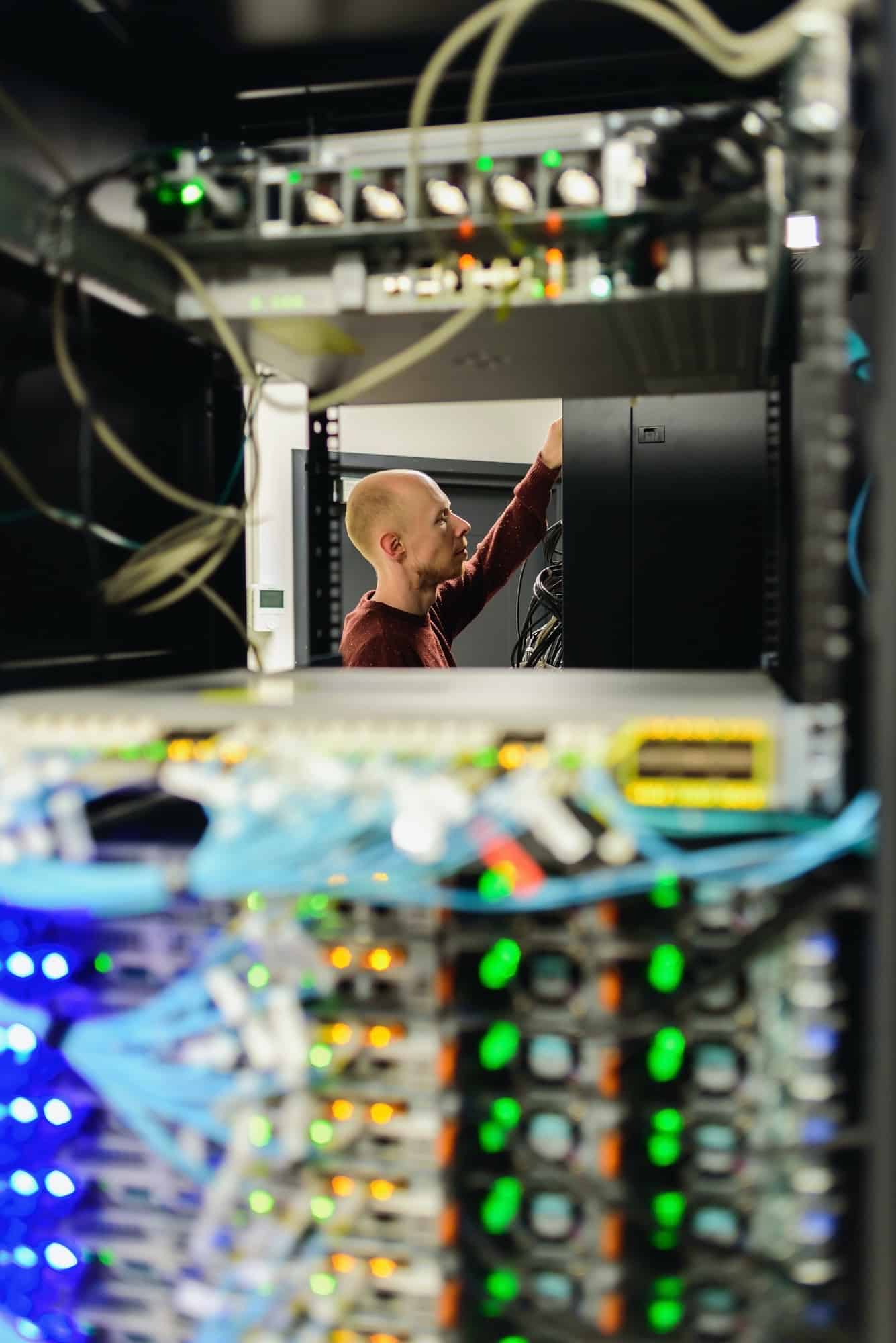 Man data center technician performing server maintenance